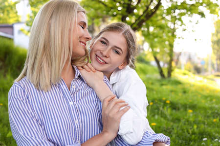 Happy mother with her daughter spending time together in park on sunny dayの写真素材