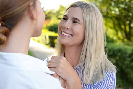 Happy mother with her daughter spending time together in park on sunny dayの写真素材