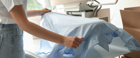 Closeup view of female worker using ironing press, banner design. Dry-cleaning serviceの写真素材