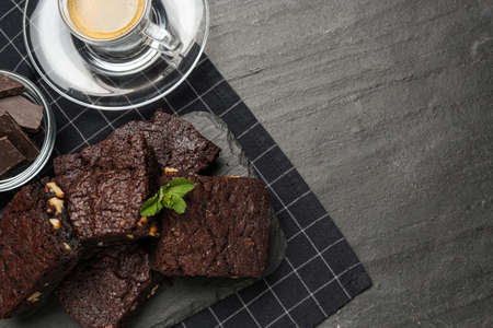 Delicious chocolate brownies with nuts and coffee on black table, flat lay. Space for textの写真素材