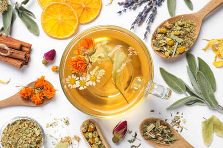 Freshly brewed tea and dried herbs on white background, top viewの写真素材