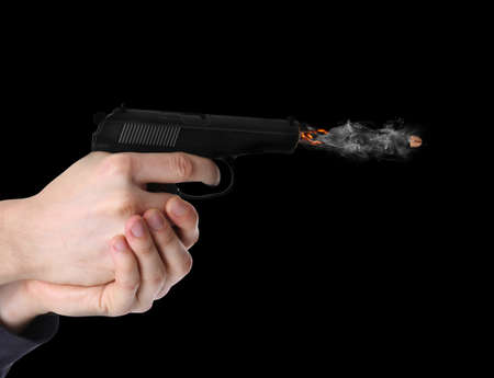 Man shooting from gun on black background, closeupの写真素材
