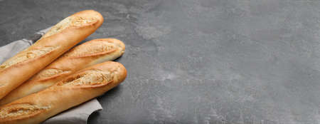 Tasty baguettes on gray table, space for text. banner designの写真素材