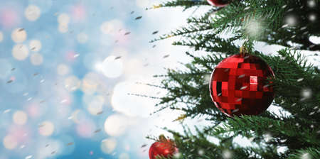 Beautiful Christmas tree with bright baubles against blurred lights on light blue background,...