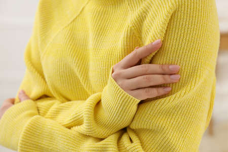 Woman touching sweater made of soft yellow fabric, closeupの写真素材