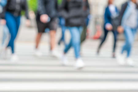 People crossing street outdoors, closeup. blurred view