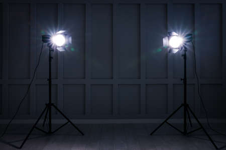 Bright white spotlights near wall indoors, space for text