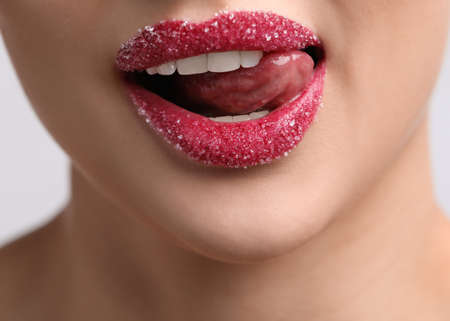 Young woman with beautiful lips covered in sugar on light background, closeupの写真素材