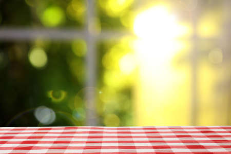 Table with red checkered cloth indoors. space for design
