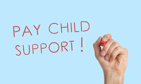 Man with marker and phrase PAY CHILD SUPPORT! on turquoise background, close up