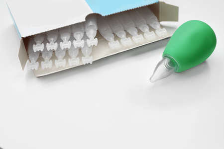 Package with single dose ampoules of sterile isotonic sea water solution and nasal aspirator on white background. Space for textの写真素材