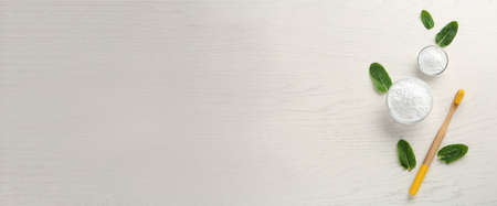 Tooth powder, brush and mint on white wooden table, flat lay with space for text. banner design