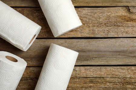 Rolls of white paper towels on wooden table, flat lay. Space for textの写真素材