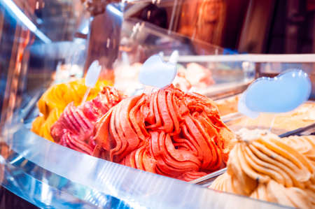 Showcase with different kinds of ice cream, closeup view