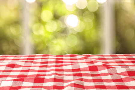 Table with red checkered cloth indoors. space for design