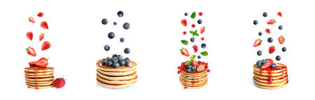 Set of delicious pancakes and different falling berries on white background, banner designの写真素材