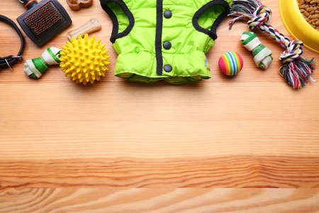 Flat lay composition with dog clothes, food and accessories on wooden table. Space for textの写真素材