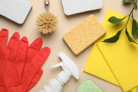 Flat lay composition with sponges and other cleaning supplies on beige backgroundの写真素材