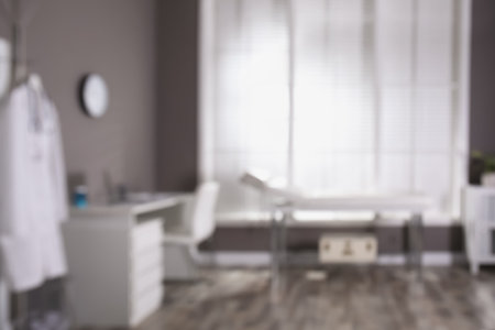 Blurred view of modern medical office with doctor's workplace and examination table. interior designの写真素材