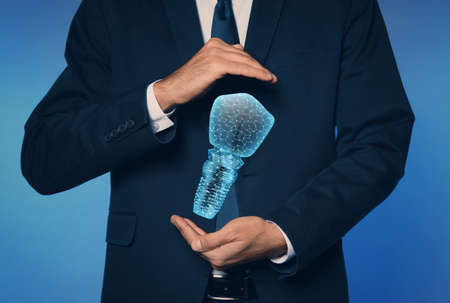 Man demonstrating virtual image of dental implant on blue background, closeupの写真素材