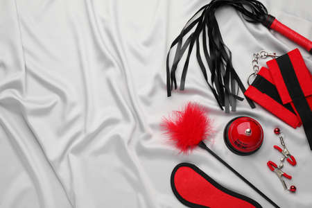 Sex toys and accessories on white fabric, flat lay. Space for textの写真素材