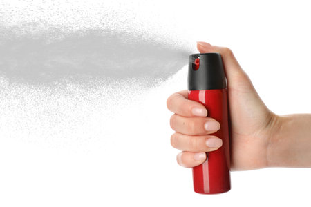Woman using pepper spray on white background, closeupの写真素材
