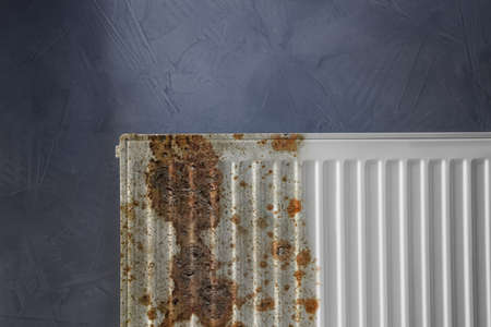 Modern panel radiator by affected rust on gray backgroundの写真素材