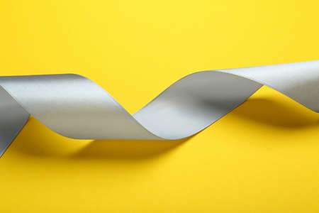 Beautiful ribbon on yellow background, closeup viewの写真素材