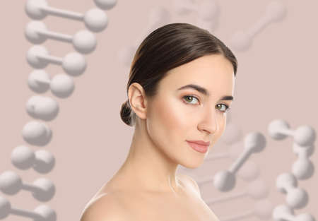 Beautiful young woman against beige background with illustration of DNA chainsの写真素材