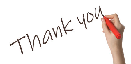 Woman writing phrase Thank You on white background, closeupの写真素材