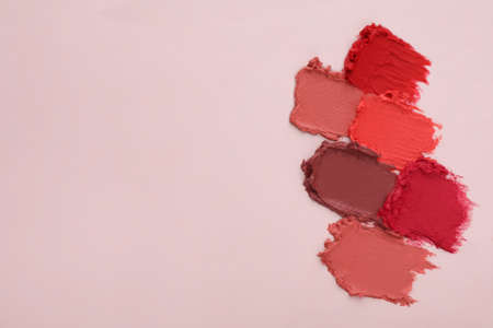 Smears of different beautiful lipsticks on light background, top view. Space for textの写真素材