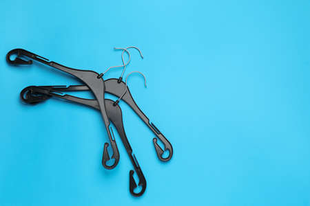Empty hangers on light blue background, flat lay. Space for textの写真素材