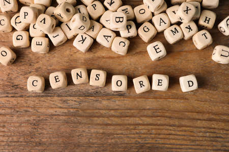Small cubes with word Censored on wooden table, flat layの写真素材