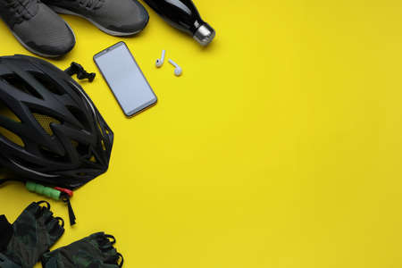 Flat lay composition with different cycling accessories on yellow background, space for textの写真素材