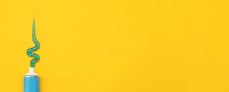 Tube with squeezed out toothpaste on yellow background, top view with space for text. banner design
