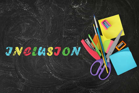 Different stationery on blackboard and word INCLUSION, flat layの写真素材