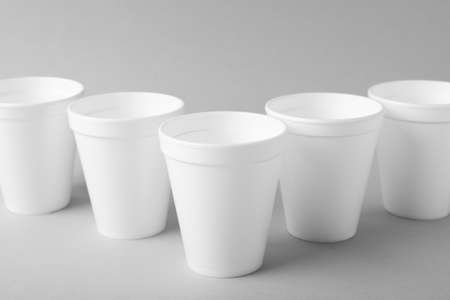 Styro-foam cups on light gray background, closeup