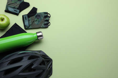 Flat lay composition with different cycling accessories and clothes on light background, space for textの写真素材