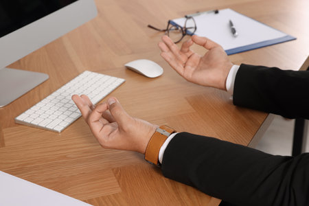 Businessman meditating at workplace, closeup. Zen conceptの写真素材