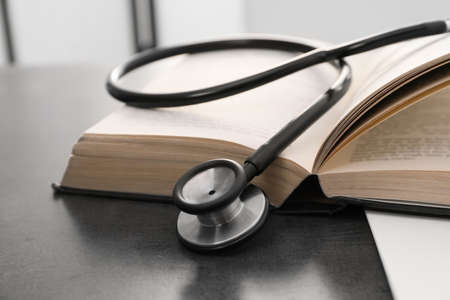 Open student textbook and stethoscope on gray table indoors, closeup. medical educationの写真素材
