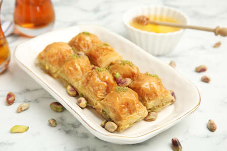 Delicious baklava with pistachios and scattered nuts on white marble tableの写真素材