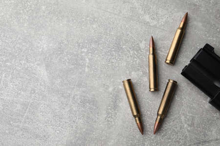 Bullets and handgun on light gray table, flat lay. Space for textの写真素材