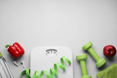 Flat lay composition with scales and measuring tape on light gray background, space for text