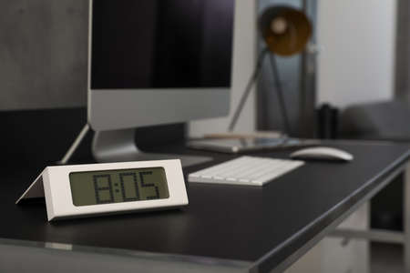 Electronic clock near computer on table indoors, space for text. interior elementの写真素材