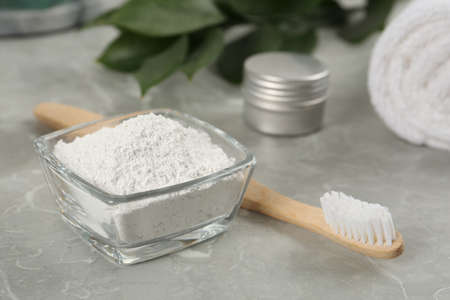 Tooth powder and brush on light gray marble table, closeupの写真素材
