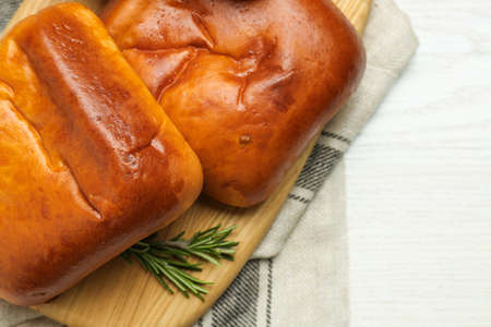 Delicious baked patties with rosemary branches on white wooden table, top view. Space for text