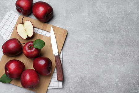 Fresh ripe red apples and knife on light gray table, flat lay. Space for textの写真素材