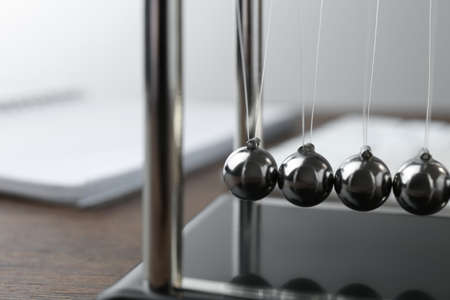 Newton's cradle on wooden table, closeup. Physics law of energy conservationの写真素材