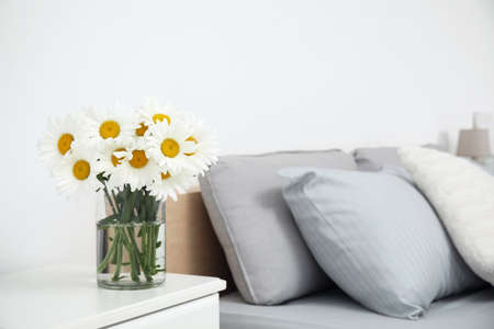 Bouquet of beautiful daisy flowers on table in bedroom, space for textの写真素材