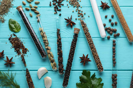 Flat lay composition with various spices, test tubes and fresh herbs on light blue wooden backgroundの写真素材